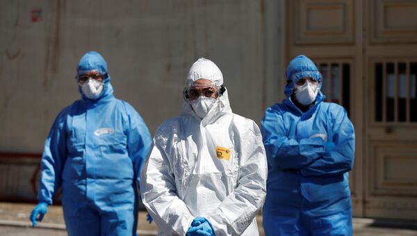 Funcionários da saúde com equipamento de proteção esperam no exterior de uma unidade logística móvel, enquanto a propagação da doença do coronavírus (COVID-19) continua em Roma, Itália, 1º de abril de 2020 - Sputnik Brasil