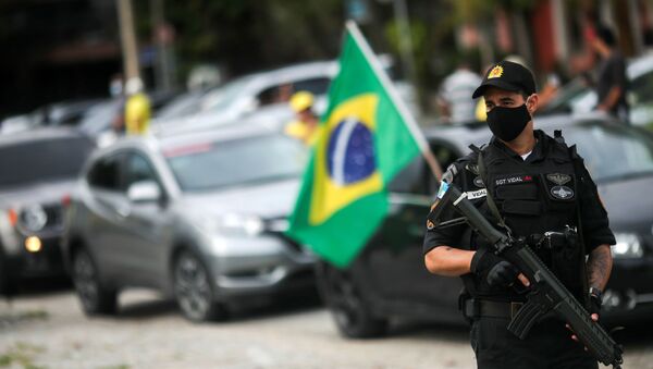 Policial usa máscara durante carreata contra medida de auto-isolamento, no Rio de Janeiro, 15 de abril de 2020 - Sputnik Brasil