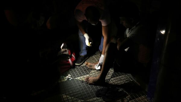 Voluntário trata o pé machucado de um morador de rua em meio à pandemia do coronavírus, no centro de São Paulo, Brasil, 28 de março de 2020 - Sputnik Brasil