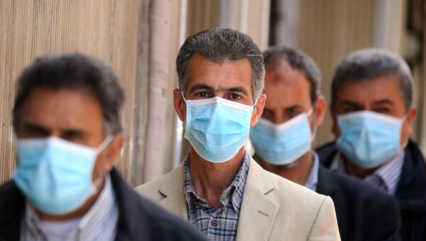Líbios usando máscaras protetoras fazem fila em frente à agência bancária, na cidade de Trípoli, 1º de abril de 2020 - Sputnik Brasil