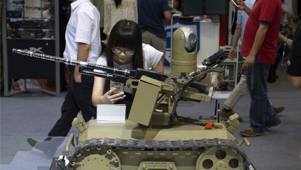 Visitante tira foto de um robô armado controlado à distância em Exposição Internacional na China - Sputnik Brasil