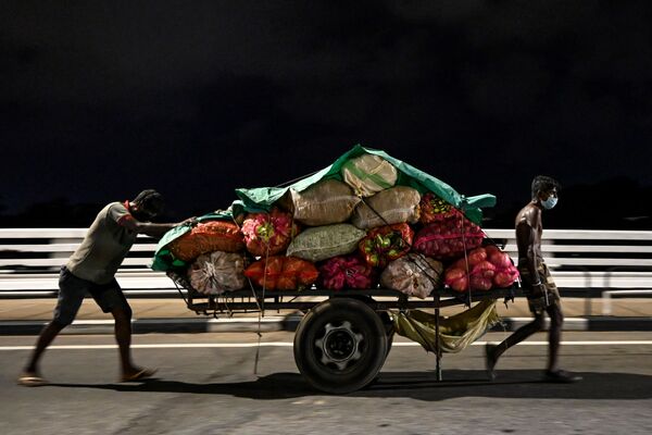 Trabalhadores com máscaras faciais, devido ao coronavírus, levam carrinho de legumes por rua de Colombo, no Sri Lanka, 11 de abril de 2020 - Sputnik Brasil