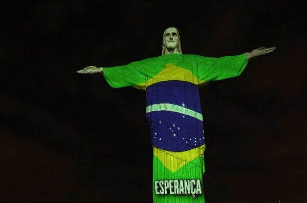 Estátua do Cristo Redentor do Rio de Janeiro é iluminada com a bandeira do Brasil, durante a pandemia do novo coronavírus, no Rio de Janeiro, 12 de abril de 2020 - Sputnik Brasil