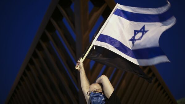 Israelense preocupado com a COVID-19 ostenta uma bandeira do país em Tel Aviv - Sputnik Brasil