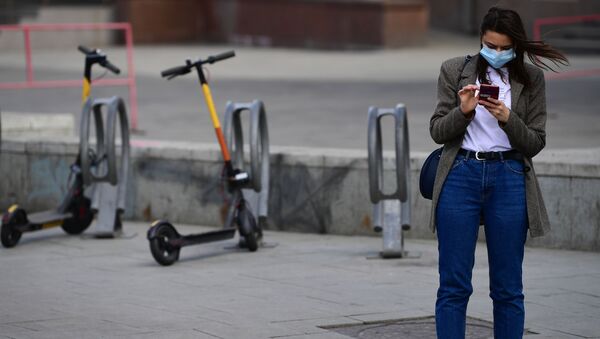 Garota com celular e máscara protetora na rua Bolshaya Dmitrovka em Moscou durante o regime de confinamento dos cidadãos - Sputnik Brasil