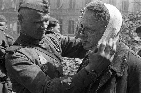 Soldado soviético faz curativo em morador de Berlim ferido - Sputnik Brasil