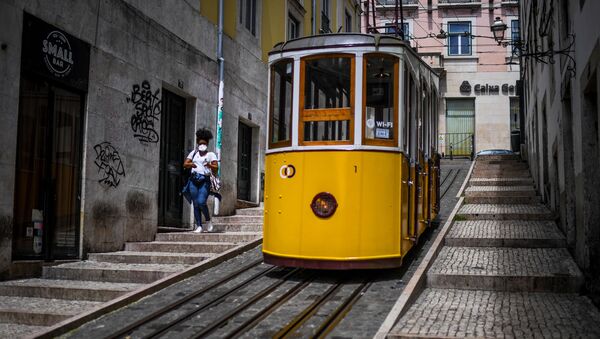 Mulher de máscara caminha em Lisboa, no primeiro dia de desconfinamento em Portugal - Sputnik Brasil