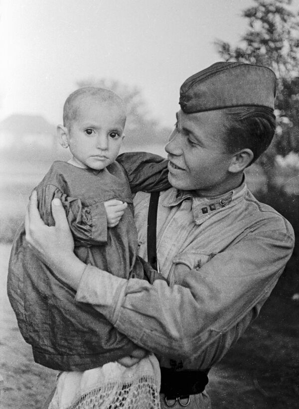 Oficial soviético segura no colo menina salva por ele do vilarejo de Elkhotovo - Sputnik Brasil