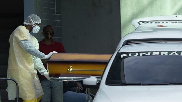 Profissional de saúde coloca um caixão de um paciente vítima da COVID-19 no Rio de Janeiro - Sputnik Brasil