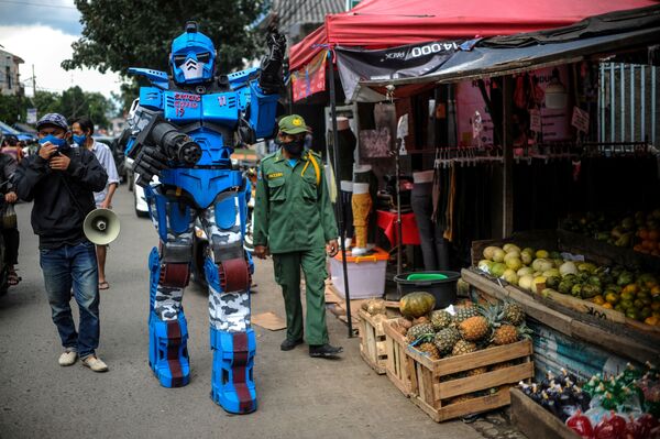 Homem vestido de transformer conclama moradores de Bandung, na Indonésia, a permanecerem em casa durante a pandemia - Sputnik Brasil