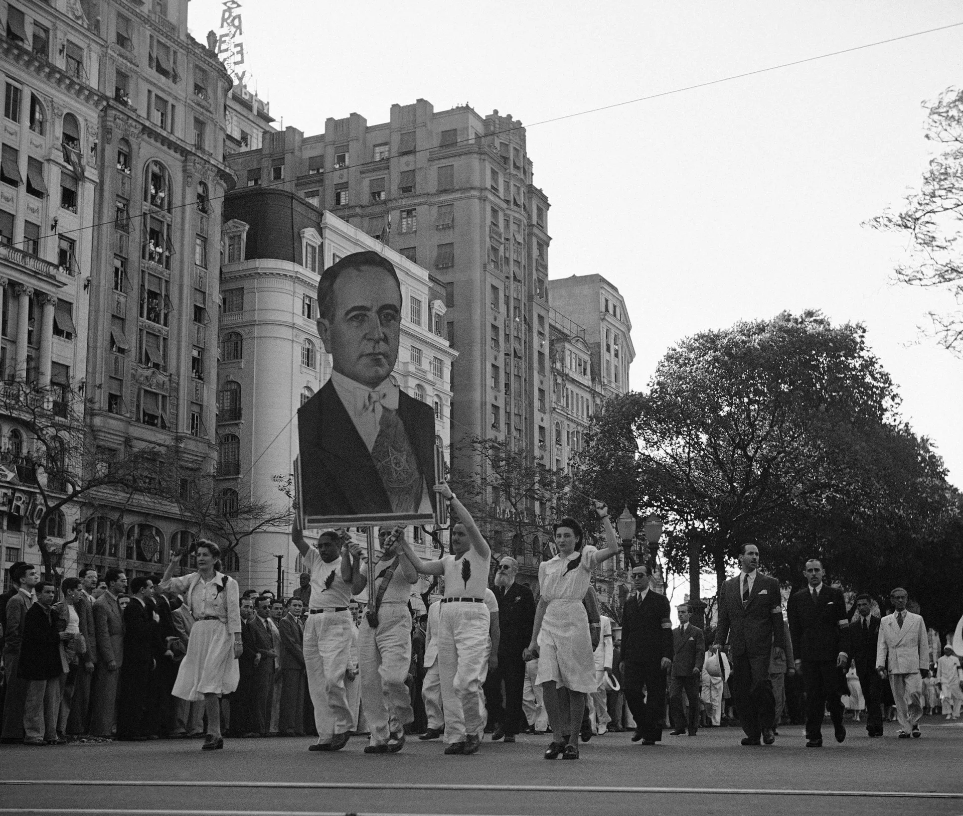Participantes de desfile com retrato de Getúlio Vargas passam pela Avenida Rio Branco, no Rio de Janeiro, 2 de setembro de 1942 - Sputnik Brasil, 1920, 25.12.2025