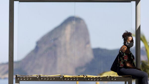 Mulher usando máscara protetora em ponto de ônibus, no Rio de Janeiro, 11 de maio de 2020 - Sputnik Brasil