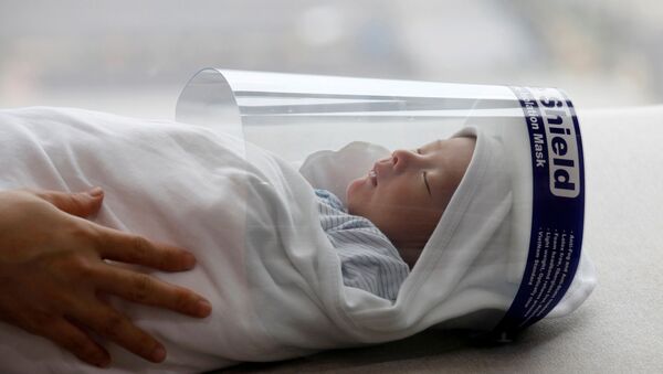 Recém-nascido usando escudo protetor durante pandemia do coronavírus em Hanói, Vietnã, 13 de abril de 2020 - Sputnik Brasil