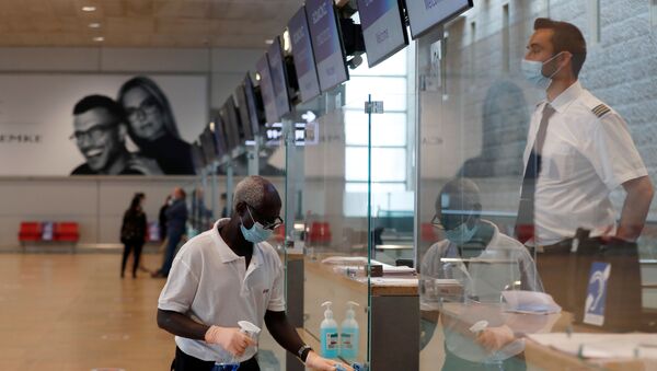 Funcionário desinfecta superfícies em um balcão de aeroporto - Sputnik Brasil