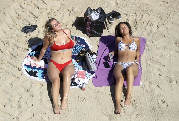 Garotas tomam banho de sol em praia de Cullercoats, no Reino Unido, 20 de maio de 2020 - Sputnik Brasil