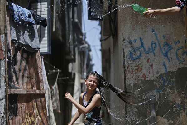 Menina palestina se refrescando durante uma onda de calor no centro da Faixa de Gaza em meio à pandemia da COVID-19, 19 de maio de 2020 - Sputnik Brasil