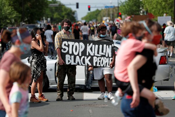 Americanos com máscaras nas ruas de Minneapolis protestam contra a morte de um cidadão negro, George Floyd, pela polícia da cidade - Sputnik Brasil