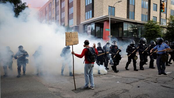 Manifestante enfrenta policiais em Raleigh, nos EUA, durante ato em resposta à morte do cidadão George Floyd - Sputnik Brasil