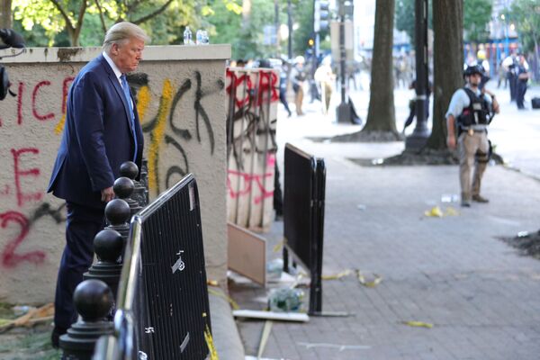 Presidente dos EUA, Donald Trump, passa por um prédio grafitado por manifestantes no parque Lafayette, em frente à Casa Branca, nos EUA - Sputnik Brasil