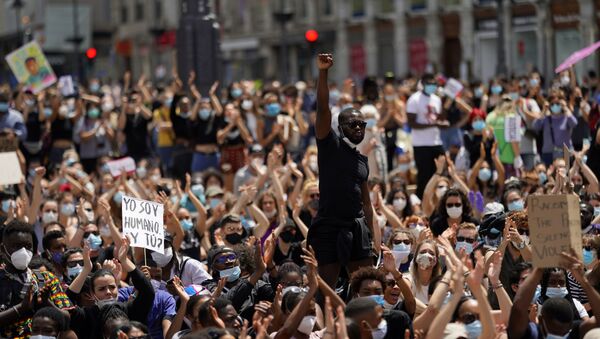 Em Madrid, um homem levanta o punho em meio aos manifestantes contra o racismo e a violência policial, em 7 de junho de 2020, em solidariedade aos protestos contra o assassinato de George Floyd, nos Estados Unidos. - Sputnik Brasil
