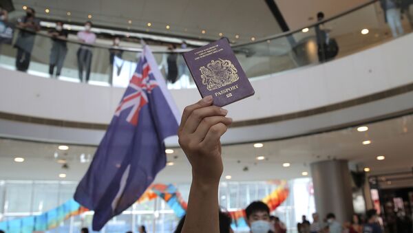 Manifestante empunha bandeira do Reino Unido e passaporte britânico em centro comercial de Hong Kong, na China, 29 de maio de 2020 - Sputnik Brasil