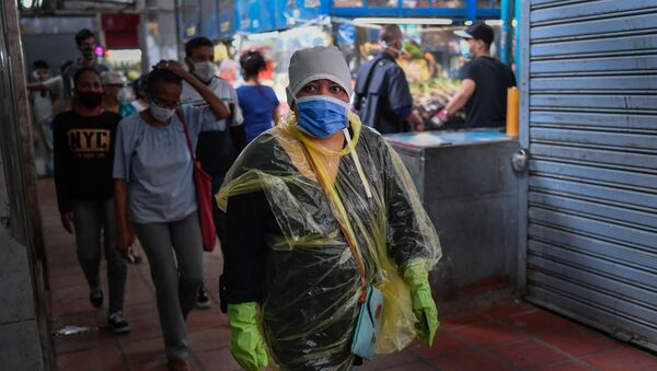 Mulher anda com máscara e luvas durante pandemia do coronavírus na Venezuela (foto de arquivo) - Sputnik Brasil