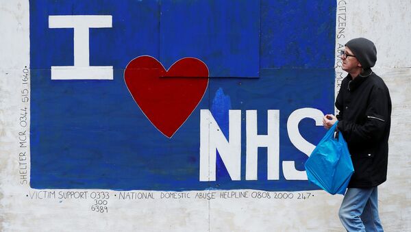 Em 12 de junho de 2020, em Manchester, um homem caminha em frente a um grafitti com a inscrição, em inglês, eu amo o NHS, em homenagem ao sistema público de saúde britânico, em meio à pandemia da COVID-19.. - Sputnik Brasil