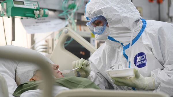 Agente de saúde cuida de paciente na Unidade de Terapia Intensiva do hospital Filatov de Moscou, na Rússia, 21 de maio de 2020 - Sputnik Brasil