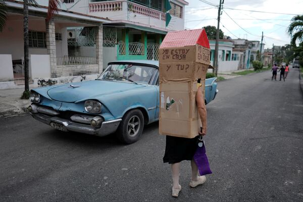 Enfermeira aposentada Feridia Rojas, 82, caminha ao lado de carro antigo em rua de Havana - Sputnik Brasil