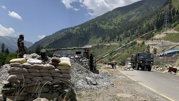 Soldados paramilitares indianos montam guarda enquanto um comboio do Exército indiano se desloca na rodovia Srinagar-Ladakh em Gagangeer, nordeste de Srinagar, Índia, 18 de junho de 2020 - Sputnik Brasil