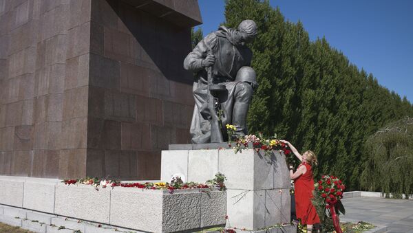 Mulher colocando flores no monumento ao soldado do Exército Vermelho na cerimônia de comemoração dos 75 anos do Dia da Vitória, distrito de Treptow, Berlim, Alemanha, 9 de maio de 2020 - Sputnik Brasil