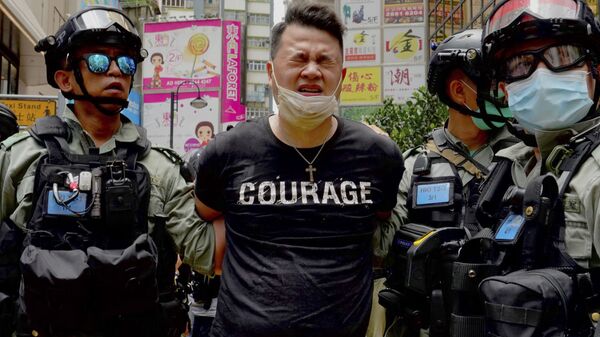 Policiais prendem manifestante atingido com gás de pimenta em Hong Kong - Sputnik Brasil