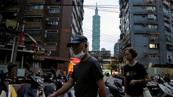 Pessoas usando máscaras para se protegerem da doença COVID-19 enquanto caminham perto do arranha-céu Taipei 101, em Taipé, Taiwan, 7 de julho de 2020 - Sputnik Brasil