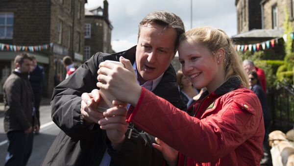 Premiê britânico David Cameron tira selfie com uma menina durante a campanha das eleições em 3 de maio de 2015 - Sputnik Brasil