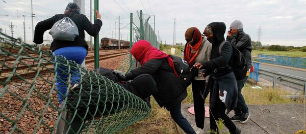 Imigrantes tentando abrir caminho através de cerca na Europa - Sputnik Brasil