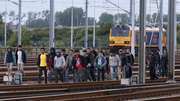 Imigrantes seguem ao longo de linha férrea em sua tentativa de atravessar o túnel do Canal da Mancha próximo a Calais, França, 29 de julho de 2015 - Sputnik Brasil