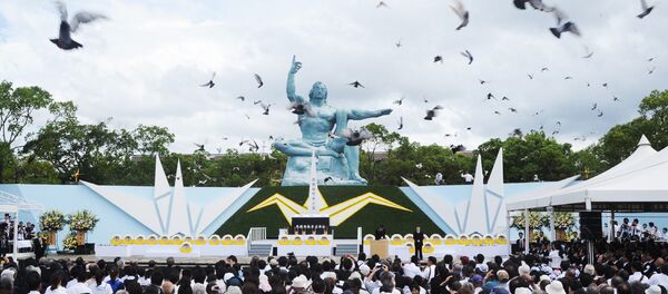 Pombos voam em torno da estátua de paz durante um serviço memorial para as vítimas do bombardeio atômico 1945, no Parque da Paz de Nagasaki em 9 de agosto de 2014. - Sputnik Brasil