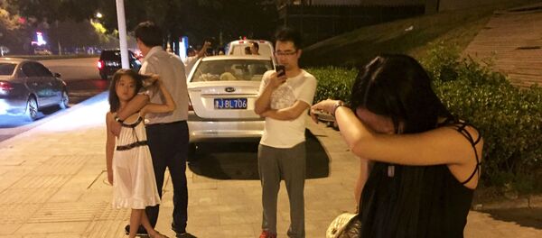 Pessoas nas ruas de Tianjin instantes após a grande explosão que sacudiu a quarta maior cidade da China nesta quarta-feira, 12 de agosto - Sputnik Brasil