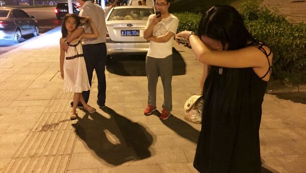 Pessoas nas ruas de Tianjin instantes após a grande explosão que sacudiu a quarta maior cidade da China nesta quarta-feira, 12 de agosto - Sputnik Brasil
