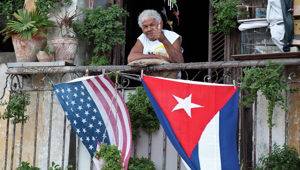 Cubano acena positivamente de sua varanda decorada com as bandeiras dos EUA e de Cuba - Sputnik Brasil