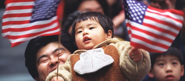 Um jovem fã japonês agita bandeiras dos EUA durante a partida final de hóquei no gelo entre os EUA e Bielorrússia, nos Jogos Olímpicos de Inverno em Nagano, 14 de fevereiro de 1998. - Sputnik Brasil