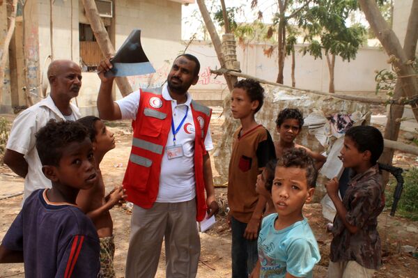 Um representante da Cruz Vermelha com um grupo de crianças iemenitas evacuadas na cidade portuária de Aden, no sul do país - Sputnik Brasil