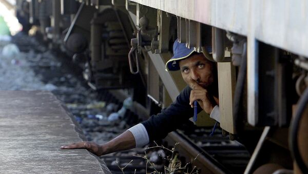 Um migrante do Oriente Médio se esconde debaixo do trem na Macedônia, 17 de agosto de 2015 - Sputnik Brasil