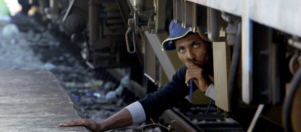 Um migrante do Oriente Médio se esconde debaixo do trem na Macedônia, 17 de agosto de 2015 - Sputnik Brasil