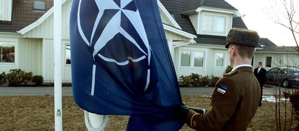 Soldado estoniano iça a bandeira da OTAN em frente da casa do ex-presidente da Estônia, Lennart Meri, na cidade de Tallinn. 29 de março de 2004. - Sputnik Brasil