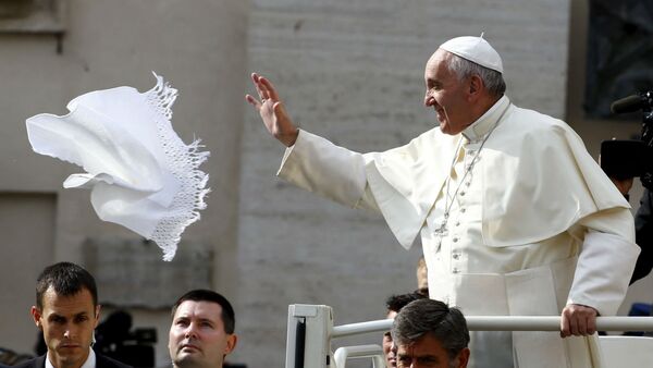 Papa Franciso tenta pegar um lenço jogado por um fiel na Praça São Pedro. - Sputnik Brasil