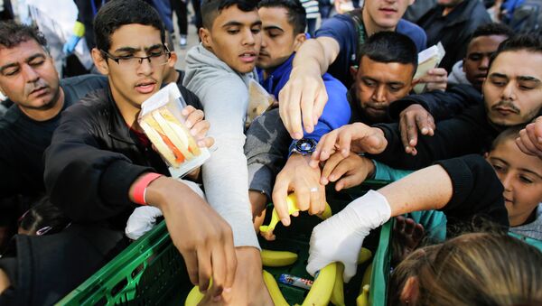 Imigrantes recebem alimentos de voluntários enquanto esperam pelo registro no centro de recepção para refugiados e asilados em Berlim nesta sexta-feira, 5 de setembro. - Sputnik Brasil