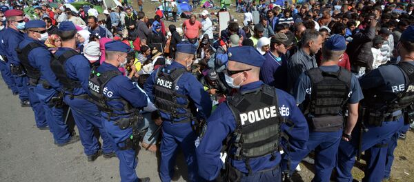 Migrantes e policiais perto da fronteira entre a Hungria e Sérvia, aldeia  Roszke, 7 de setembro de 2015 - Sputnik Brasil