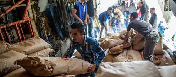 Unloading Russian EMERCOM plane with humanitarian aid which arrived to Latakia Airport in Syria - Sputnik Brasil