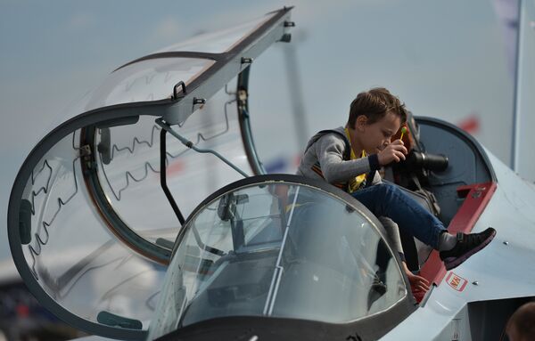 Um jovem visitante do salão aeroespacial MAKS 2015 examina a cabine de um Yak-130 Um jovem visitante do salão aeroespacial MAKS 2015 examina a cabine de um Yak-130 - Sputnik Brasil